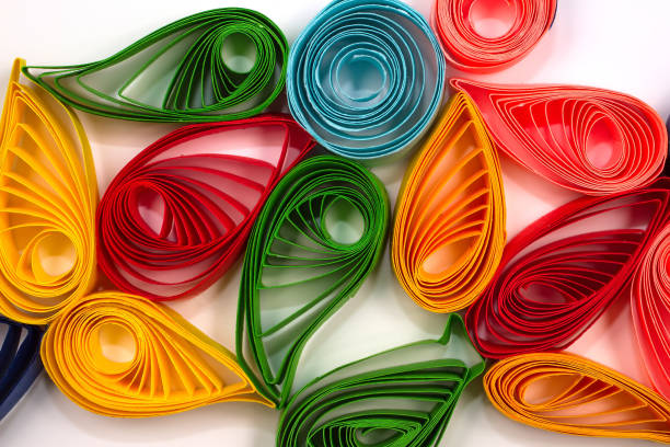 Patterns from strips of colored paper using the quilling technique. Multicolored ornament on a white background.